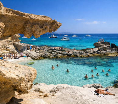 Playa de Migjorn en Formentera con rocas y agua turquesa en un entorno natural | hostal boutique en San Antonio Ibiza