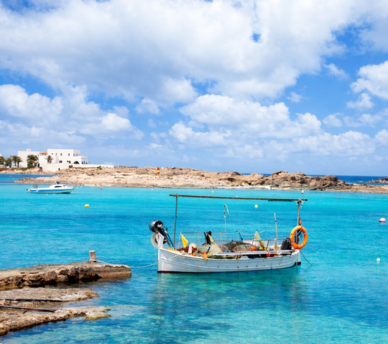 Barco sobre agua cristalina en Es Pujols y Sa Roqueta, Formentera | hostal boutique en San Antonio Ibiza