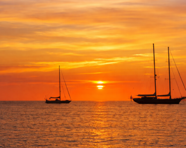 Atardecer en barco frente a la costa de San Antonio Ibiza, una de las experiencias más especiales cerca de un hostal boutique en San Antonio Ibiza