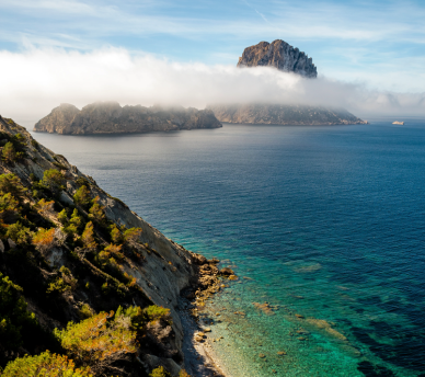 Vista del islote Es Vedrà en Ibiza al atardecer, punto imprescindible en rutas y excursiones recomendadas por Hostal Rosell Boutique.