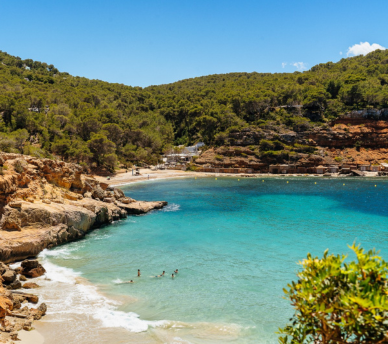 Descubre Cala Salada, una de las playas más bonitas de Ibiza, con aguas turquesas y ambiente natural. A solo minutos del Hostal Rosell Boutique en San Antonio.