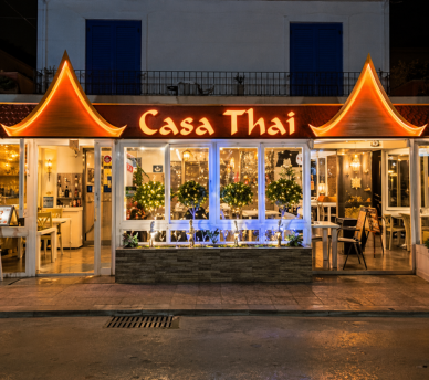 Fachada iluminada de Casa Thai en San Antonio Ibiza desde hostal boutique en San Antonio Ibiza