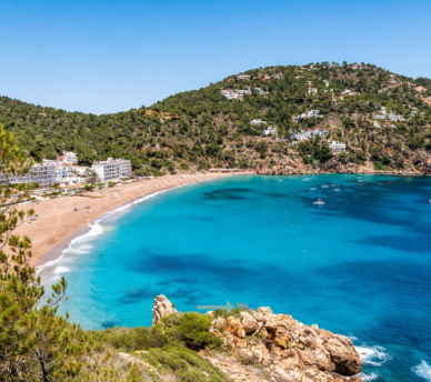 Cala de aguas turquesas en la costa de San Antonio Ibiza, un paisaje ideal para descubrir desde un hostal boutique en San Antonio Ibiza