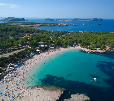 Vista aérea de Cala Bassa con aguas turquesas y arena clara, una cala fácil de llegar desde un hostal boutique en San Antonio Ibiza