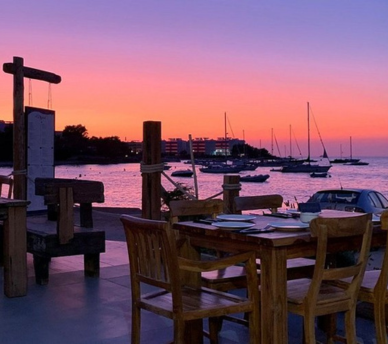 Terraza de Es Virot con vistas a la bahía de San Antonio al atardecer, una opción para cenar junto al mar cerca de un hostal boutique en San Antonio Ibiza.