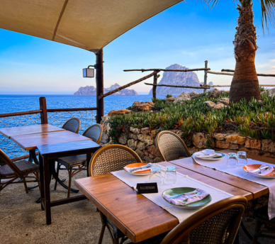 Mesa con vistas al mar en Es Boldadó, restaurante cerca de Cala d’Hort para cenar frente a Es Vedrà desde un hostal boutique en San Antonio Ibiza.